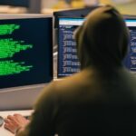 Cyberattack warning alerts overlaying industrial PLM engineering blueprints on screens
