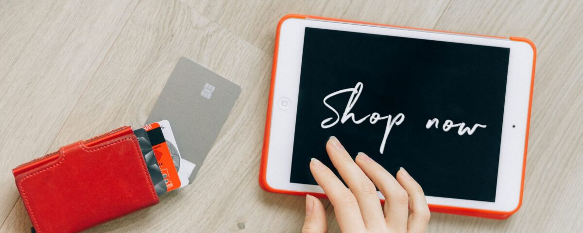 Open wallet with credit cards scattered next to laptop showing security alerts
