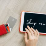 Open wallet with credit cards scattered next to laptop showing security alerts