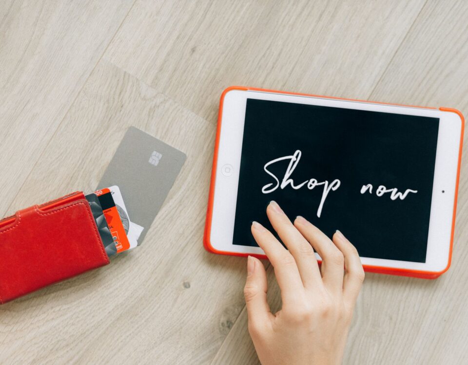 Open wallet with credit cards scattered next to laptop showing security alerts