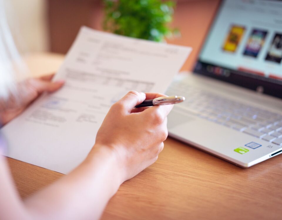 Professional performing a personal security audit on a laptop with checklist