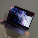 Laptop screen showing alternating corrupted and intact files in a folder