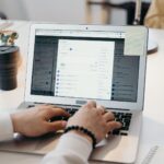 Office worker carefully examining a suspicious phishing email on laptop