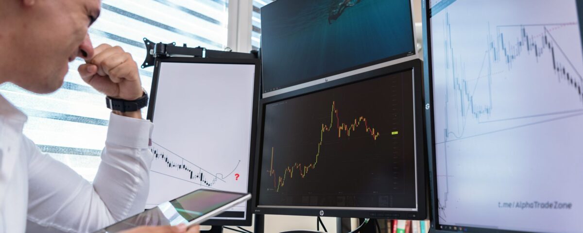 Compliance officer reviewing AI governance dashboards on multiple monitors