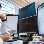 Compliance officer reviewing AI governance dashboards on multiple monitors