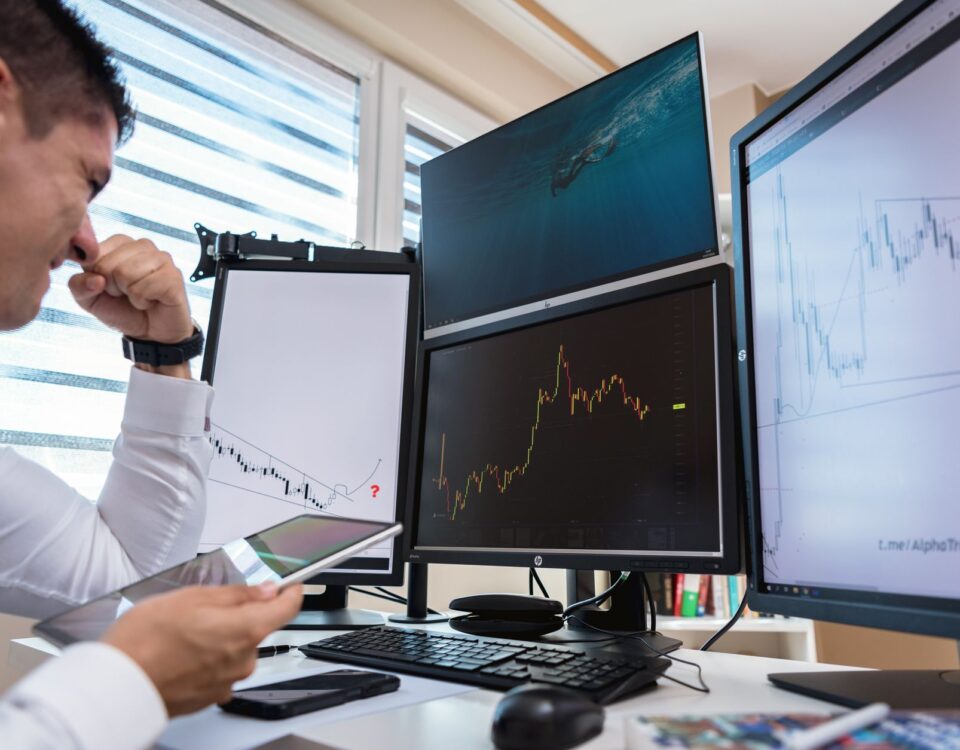 Compliance officer reviewing AI governance dashboards on multiple monitors
