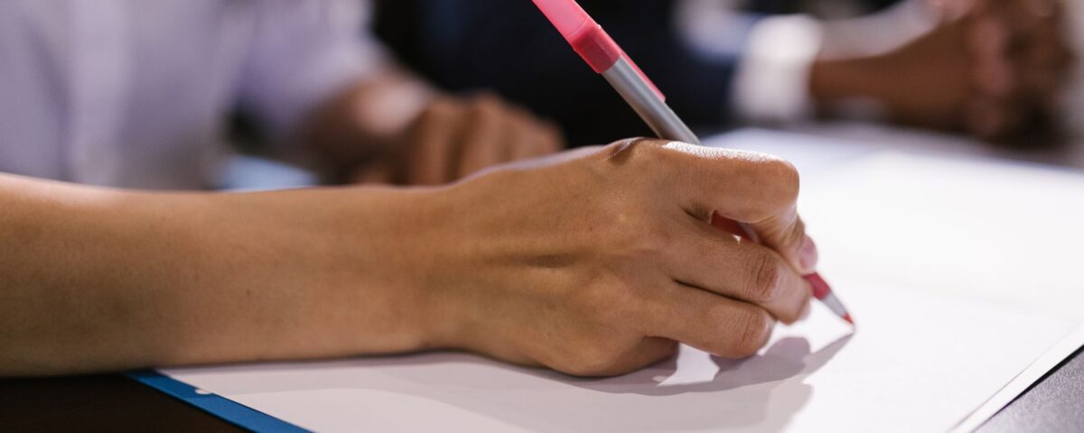 Robotic arm writing on legal document at office desk with books