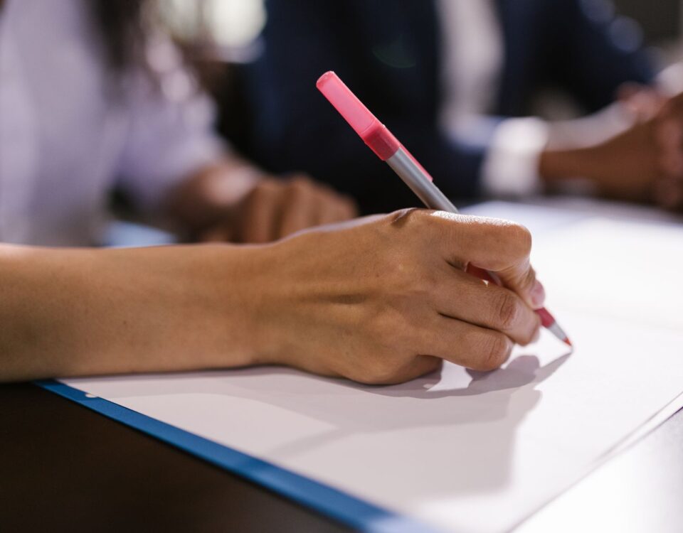 Robotic arm writing on legal document at office desk with books