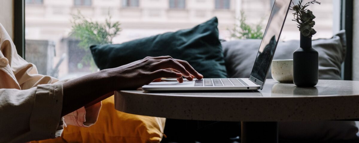 Professional typing on laptop with AI assistant interface visible on screen
