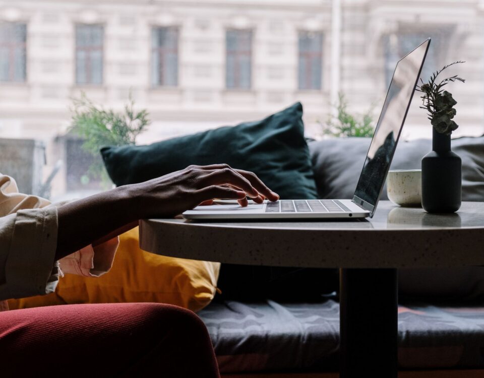 Professional typing on laptop with AI assistant interface visible on screen