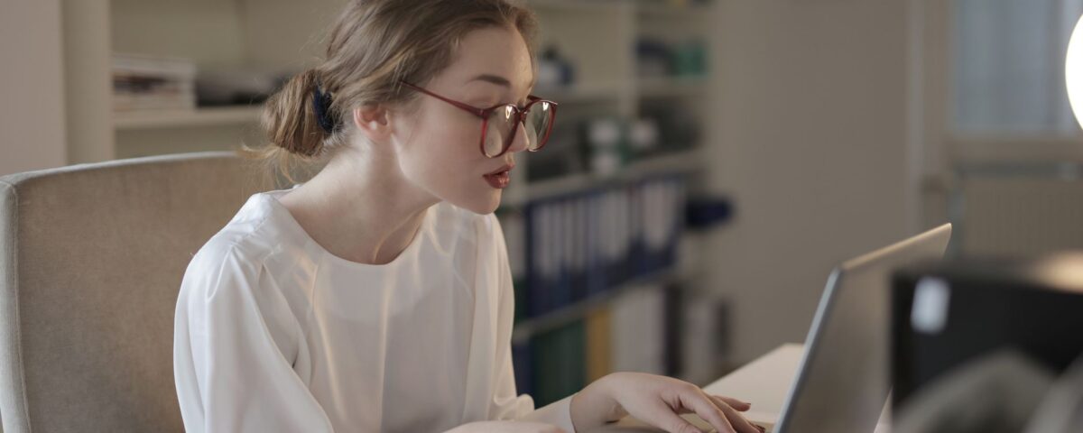 Security researcher typing a vulnerability report on a laptop at night