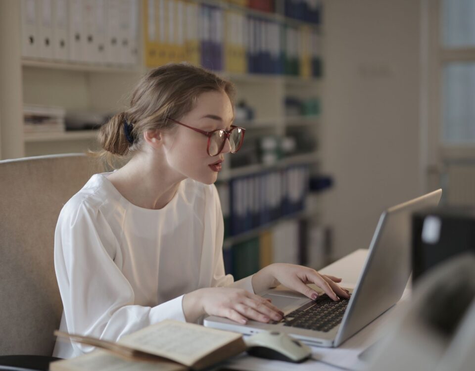 Security researcher typing a vulnerability report on a laptop at night