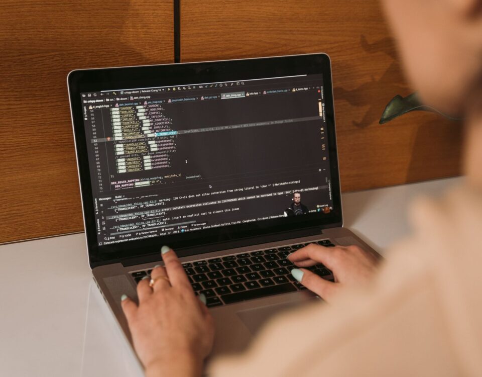 Developer laptop showing AI-assisted code editor with multiple open files