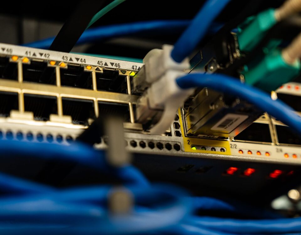 Enterprise server rack with dense colored network cables and blinking LED indicators