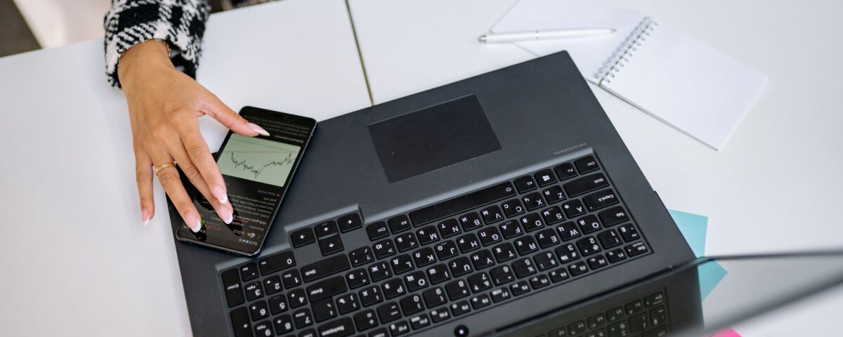 Employee using smartphone MFA code to log into corporate laptop