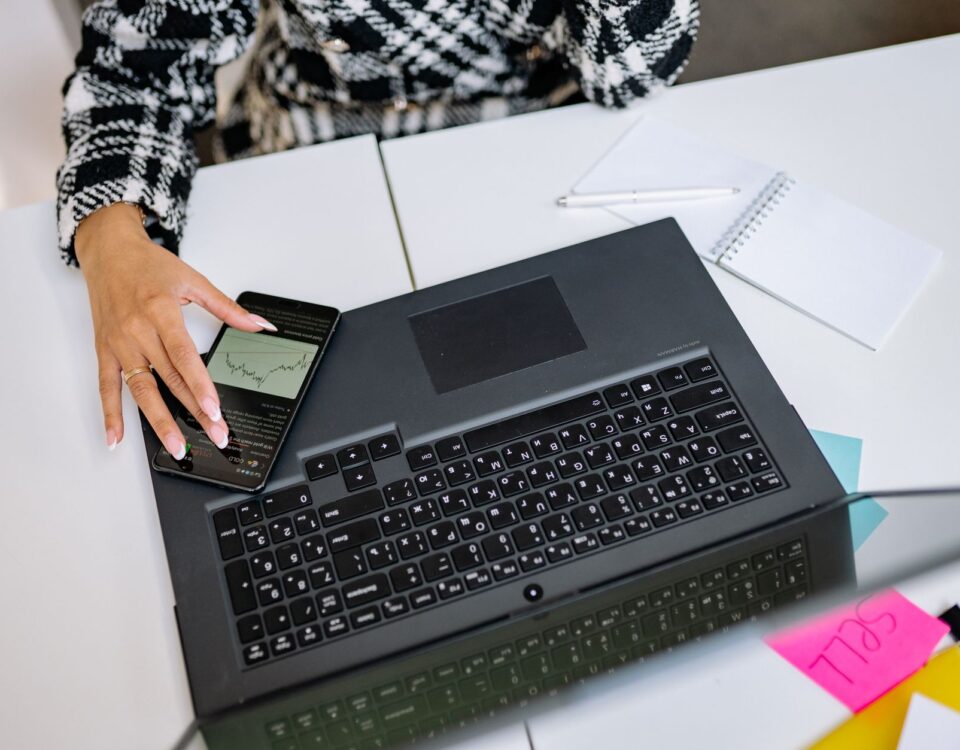 Employee using smartphone MFA code to log into corporate laptop