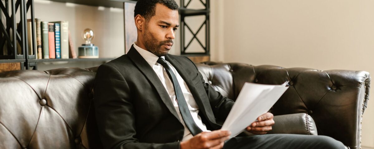 Auditor reviewing ISO compliance framework documents at corporate office desk