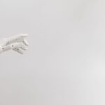Robotic arm pressing keys on a glowing keyboard in server room