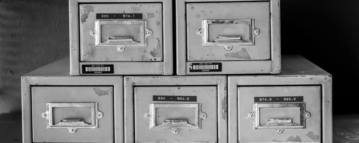 Open filing cabinet with corrupted glowing documents next to enterprise servers