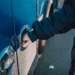 Gloved hand bypassing a reinforced security lock on metal gate