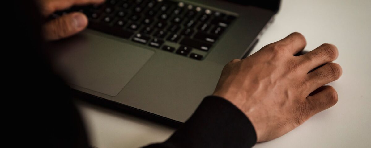Researcher analyzing neural network code on laptop screen for AI security vulnerabilities