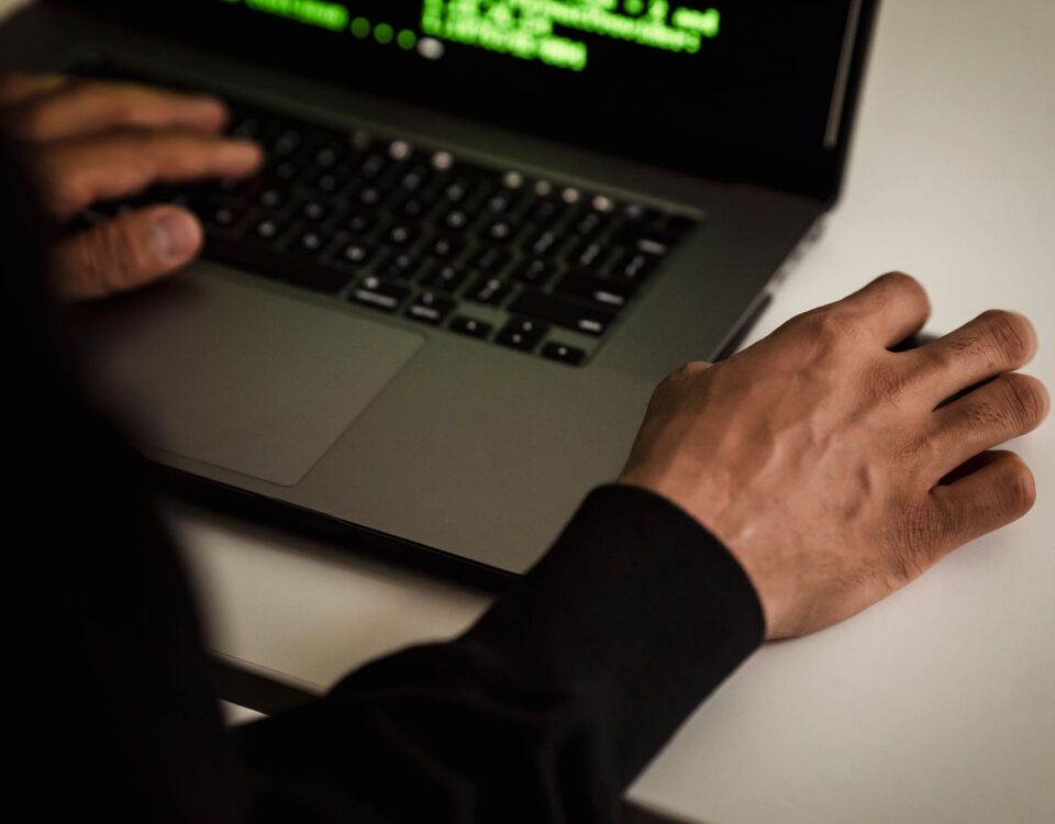 Researcher analyzing neural network code on laptop screen for AI security vulnerabilities