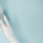 Two robotic arms exchanging a glowing digital document on an assembly line