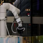 Robotic arm pressing keyboard keys in a dark server room