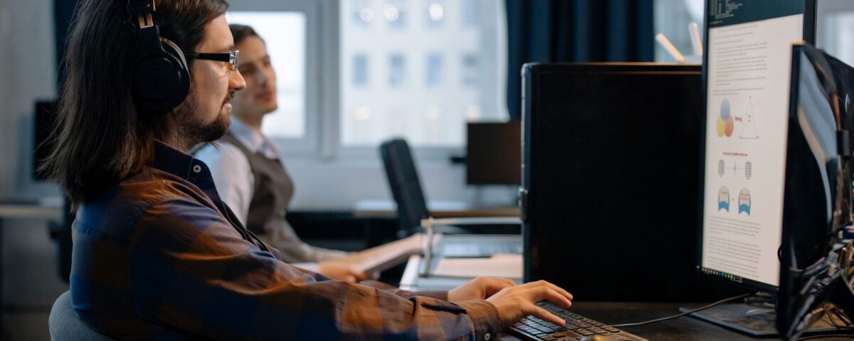 Security analyst reviewing AI pipeline code logs on dual monitors