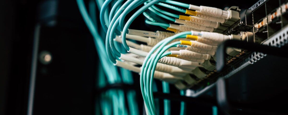 Technician inspecting open server rack in enterprise data center aisle