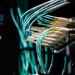 Technician inspecting open server rack in enterprise data center aisle