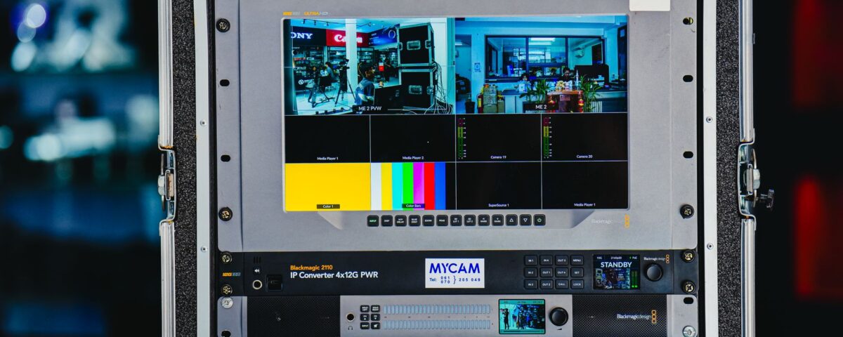 Security analyst monitoring multi-cloud dashboards across multiple server room screens