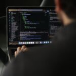 Security engineer reviewing AI plugin code on dual monitors in office