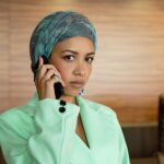 Corporate executive on phone call with audio waveform fraud alert on monitor