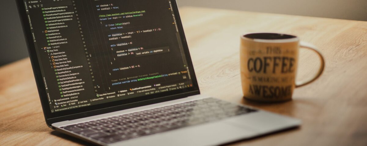 Developer laptop with code editor open and USB drives connected at desk