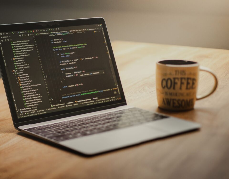 Developer laptop with code editor open and USB drives connected at desk