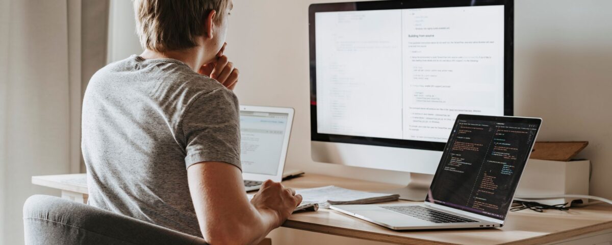 Developer reviewing SAST security scan results on code editor monitors