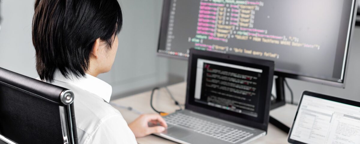 Developer workstation with dual monitors displaying code and security key attached