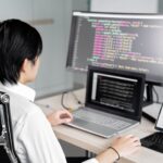 Developer workstation with dual monitors displaying code and security key attached
