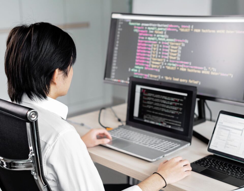 Developer workstation with dual monitors displaying code and security key attached