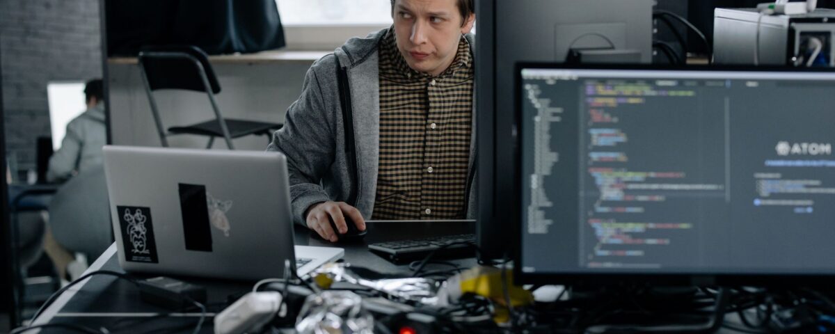 Developer reviewing GraphQL API query code on terminal screens at desk