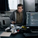 Developer reviewing GraphQL API query code on terminal screens at desk