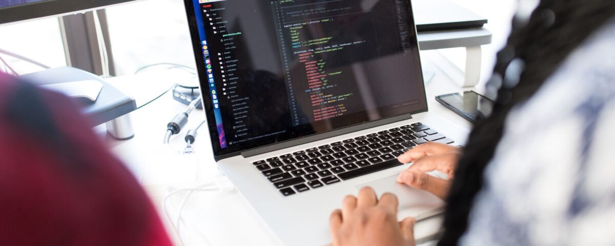 Developer laptop displaying code editor with security key attached